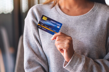 Closeup image of a woman holding and showing credit card