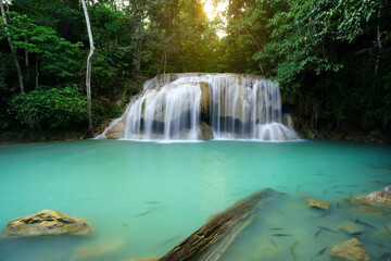 waterfall clear emerald water or blue pool with spa fish on summer season with rock and tree timber for holiday relax travel in green jungle or forest at erawan waterfall floor 2 for nature landscape