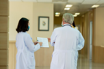 Obraz premium Doctors team wearing mask consult while walking at hospital
