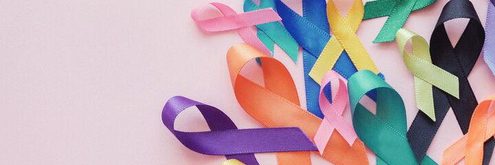 All color ribbons on pink background, cancer awareness, World cancer day