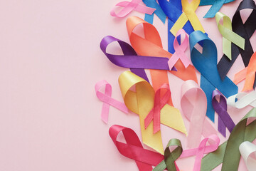 All color ribbons on pink background, cancer awareness, World cancer day