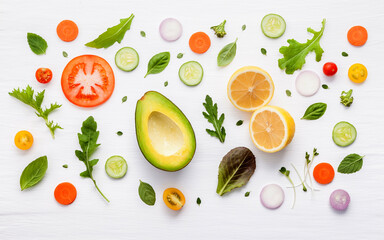 Food pattern with raw ingredients of salad, lettuce leaves, cucumbers, tomatoes, carrots, broccoli, basil ,onion and lemon flat lay on white wooden background. - 404194978