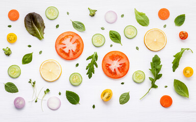 Food pattern with raw ingredients of salad, lettuce leaves, cucumbers, tomatoes, carrots, broccoli, basil ,onion and lemon flat lay on white wooden background. - 404194983
