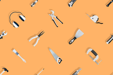 Tools seamless pattern. Various construction tools on an orange background.