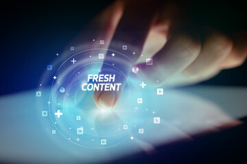 Finger touching tablet with social media icons and FRESH CONTENT