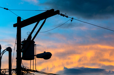 Public light pole silhouette at sunrise, dramatic sky, power of illumination, technology and...