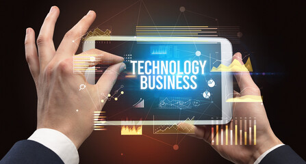 Close-up of hands holding tablet with FACILITY MANAGEMENT inscription, modern business concept