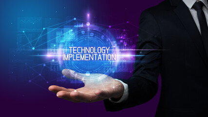 Man hand holding TECHNOLOGY IMPLEMENTATION inscription, technology concept