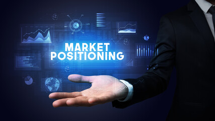 Hand of Businessman holding MARKET POSITIONING inscription, business success concept