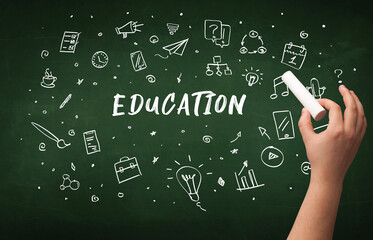 Hand drawing EDUCATION inscription with white chalk on blackboard, education concept