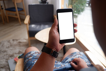 Mockup picture of business man's hands holding smart phone with white blank screen in modern place.
