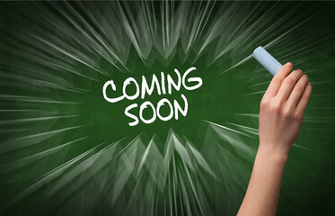 Hand drawing COMING SOON inscription with white chalk on blackboard, online shopping concept