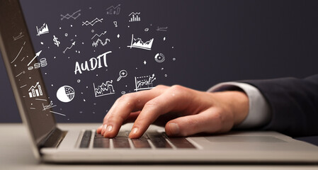 Obraz na płótnie Canvas Businessman working on laptop with AUDIT inscription, modern business concept
