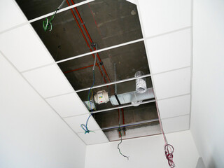 KUALA LUMPUR, MALAYSIA -JULY 24 2020: The suspended ceiling, electrical wiring, cabling and mechanical equipment under installation.  It is hanging at the floor soffit. Cover by ceiling board. 