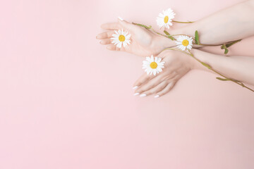 women hands with flowers, natural cosmetics concept. Natural beauty hand cosmetics with flower extract, product. Summer Fashion woman hand on the table with flower, skin care.