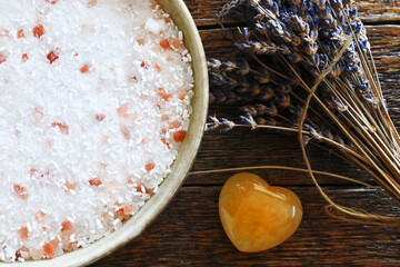 A top view image of homemade oatmeal and honey bath salts with dried lavender flowers on a dark...