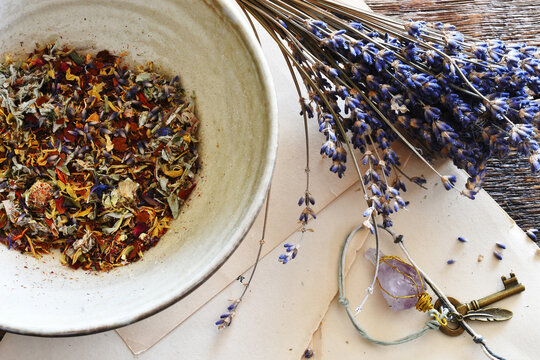 A top view image of a bowl of home made dried tea leaves with dried lavender and vintage paper.
