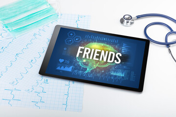 Tablet pc and medical tools with FRIENDS inscription, social distancing concept
