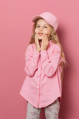 Little girl in pink clothes and a medical mask on a pink background