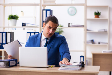 Fototapeta premium Young handsome employee sitting in the office