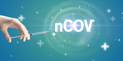Obraz na płótnie Canvas Syringe needle with virus vaccine and nCOV abbreviation, antidote concept