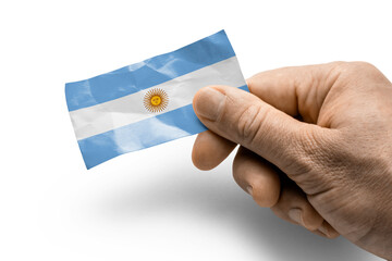 Hand holding a card with a national flag the Argentina