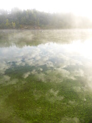 Fototapeta na wymiar Algae and clouds in the Volga River. And there's a fog over the river