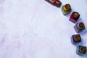 multicolored chalk paints stand in glass bottles on a pink background