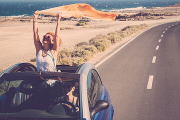 Concept of travel happiness with adult beautiful couple of women driving a car and enjoying the...