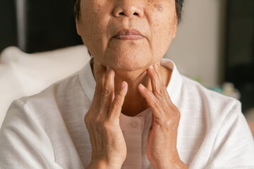 Fototapeta premium Senior adult women touching the neck feeling unwell coughing with sore throat pain .Healthcare and medicine concept