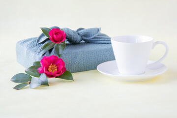 風呂敷包みと赤い山茶花とコーヒー