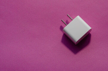 White wall AC adapter on a pink background.