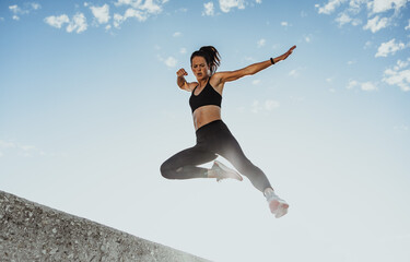 Fototapeta na wymiar Fitness woman jumping from wall