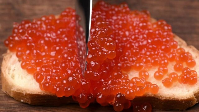 slice of white bread smeared with red caviar, close-up