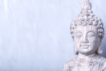Fototapeta na wymiar Meditating Buddha Statue on bright background. Soft focus. Copy space. 