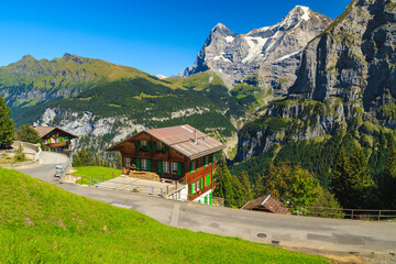 Obraz premium Wooden houses and high snowy mountains, Murren mountain resort, Switzerland