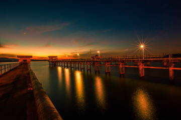 Fototapeta premium The background of the bridge stretches into the sea, with twilight light in the morning, beautiful colors, sky wallpaper and refreshing surroundings.