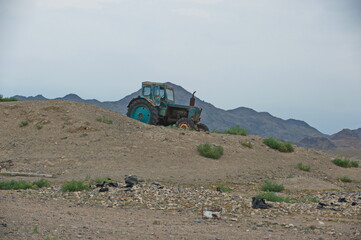 Almaty, Kazakhstan - 06.25.2013 : Old tractor on the slope of a sandy hill in the Altyn Emel Nature...