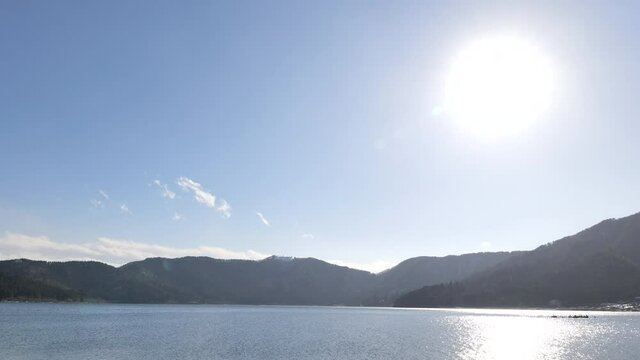 Lake Yogo in Shiga Prefecture in winter, the surface of the pond illuminated by the strong sunlight.