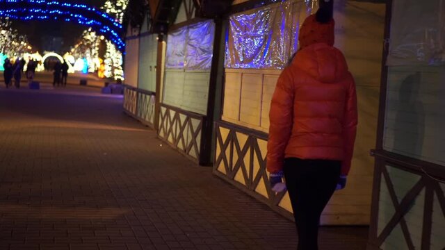 The girl walks at the Christmas market during a pandemic
