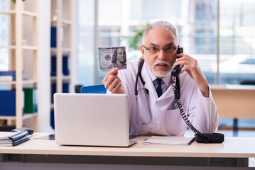 Old male doctor in remuneration concept