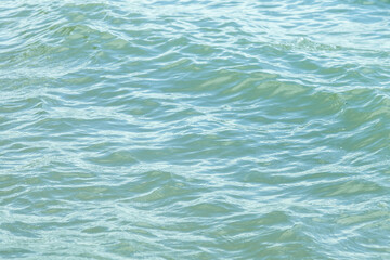 Close-up of a river with undulating waves with muddy gray water in cloudy weather. Background for wallpaper or screensaver on your desktop.