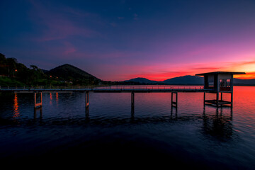 Fototapeta premium The background of the bridge stretches into the sea, with twilight light in the morning, beautiful colors, sky wallpaper and refreshing surroundings.