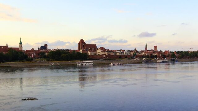 Panoramic view of Torun city and Wisla (Vistula) river at sunset. Sailing touristic boat. Poland, summer 2019