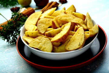 Bowl of uncooked raw spiced potato wedges .ready for cooking.