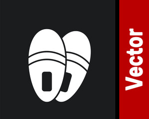 White Slippers icon isolated on black background. Flip flops sign. Vector.