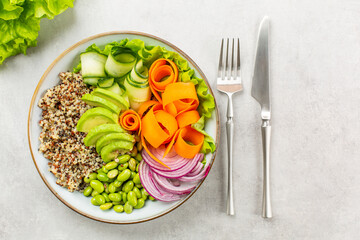 Buddha bowl - healthy  and balanced food concept. Quinoa, edamame beans, avocado, ququmber, carrot, red onion and green salad.