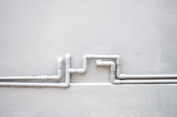 Connecting the PVC pipe on the gray wall surface