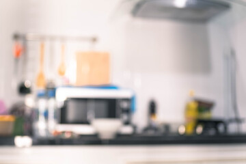 Blurred man asian cooking in kitchen of home He holds bowl and  spatula  to great hand on microwave in kitchen blurred background