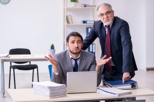 Old boss and his young assistant working in the office